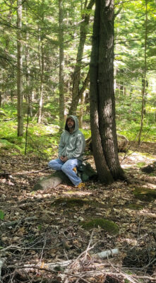 man in woods during forest therapy walk in maine 1